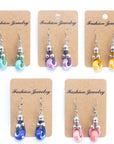 Angelco Accessories Ceramic bead cork drop earrings in all colours , presented on cardboard cards on white flatlay