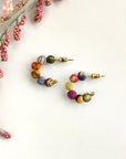 Kantha mini hoop stud earrings on white bench with florals on left