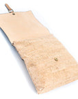 Angelco Accessories cork backpack shown laying with flap open and showing snap button closure on white background