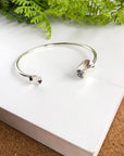 Angelco Accessories hammered coin cuff - silver - flatlay on white board with green fern