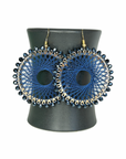 Angelco Accessories Colour burst circle earrings hanging on ceramic cup on white background - indigo