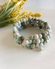 Angelco Accessories Spiral kantha bangle - sea foam on a table top with yellow flowers