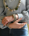 Angelco Accessories Spiral kantha bangle - sea foam worn on a person's wrist with other jewellery