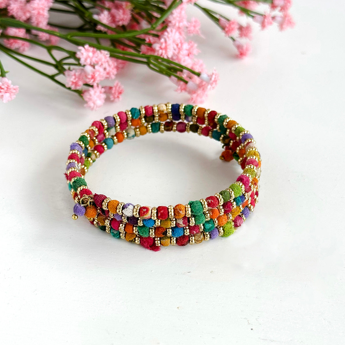 Angelco Accessories mini kantha bead bangle displayed with pink flowers in background