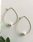 Angelco Accessories Floating pearl hoop earrings - on white flatlay with linen and green leaves