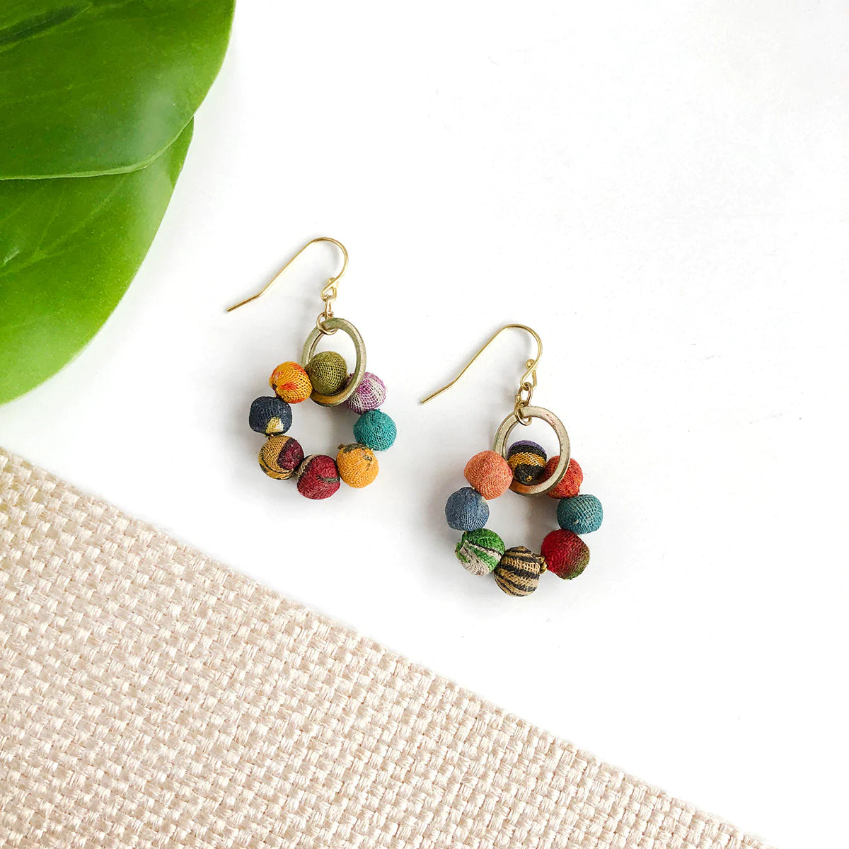 Angelco Accessories Kantha orbit earrings - flatlay with leaf and  woven mat
