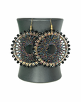 Angelco Accessories colour burst circle earrings hanging on ceramic cup on white background - black colourful