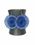 Angelco Accessories Colour burst circle earrings hanging on ceramic cup on white background - cobalt