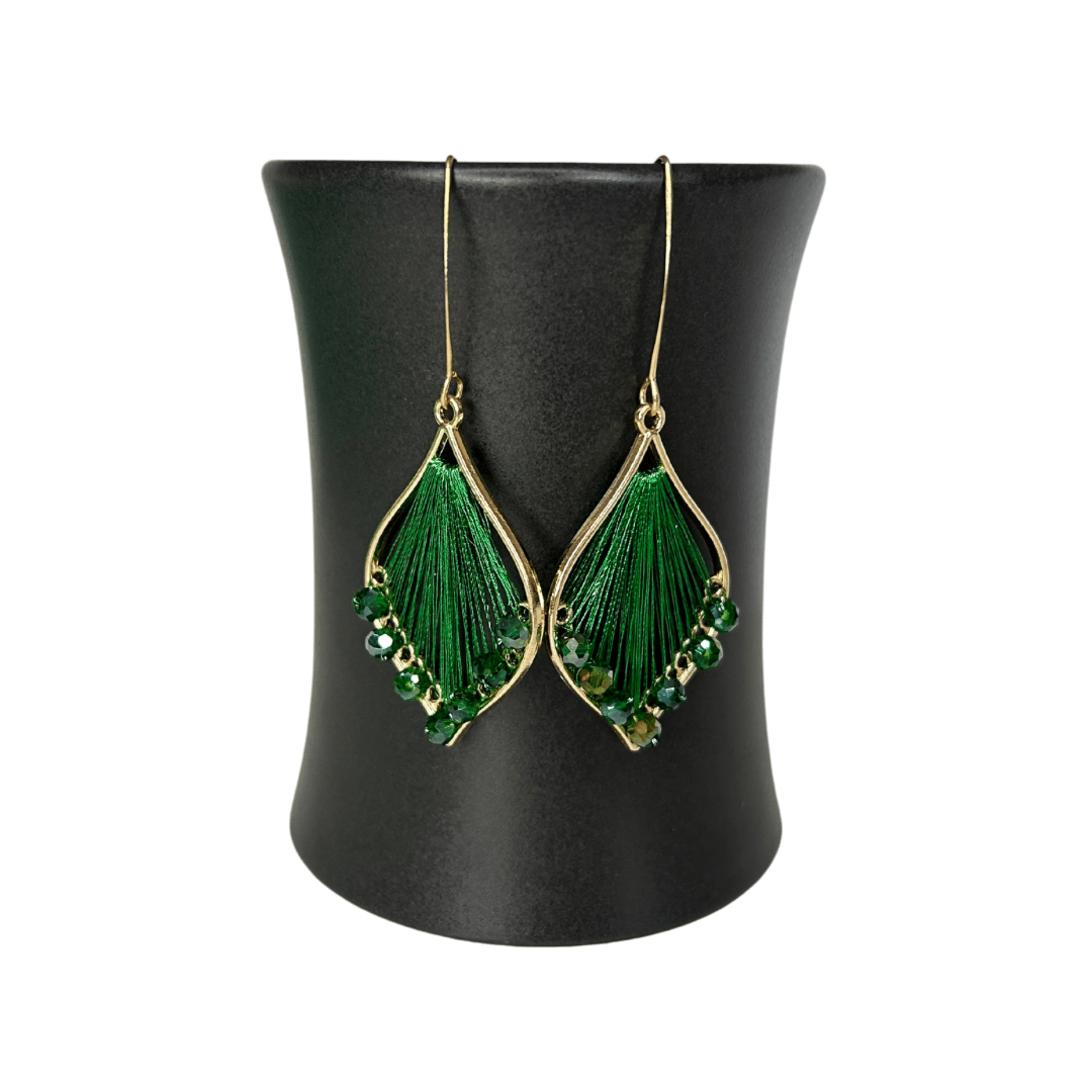 Angelco Accessories Exquisite thread earrings in green colour hanging on a ceramic cup on a white background
