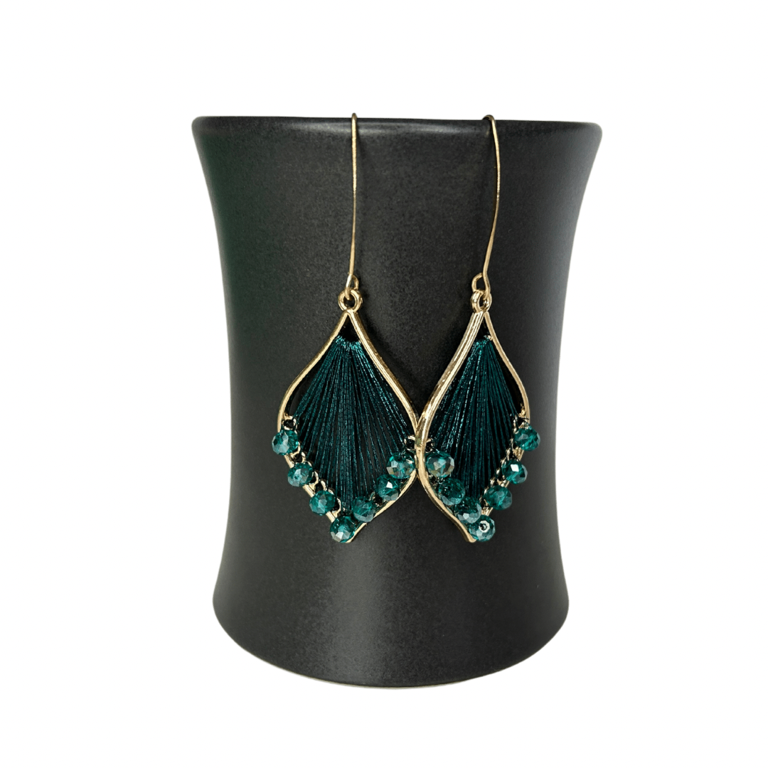 Angelco Accessories Exquisite thread earrings in teal colour hanging on a ceramic cup on a white background
