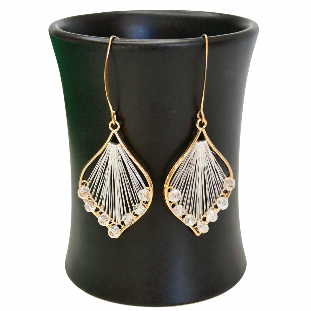Angelco Accessories Exquisite thread earrings in white colour hanging on a ceramic cup on a white background